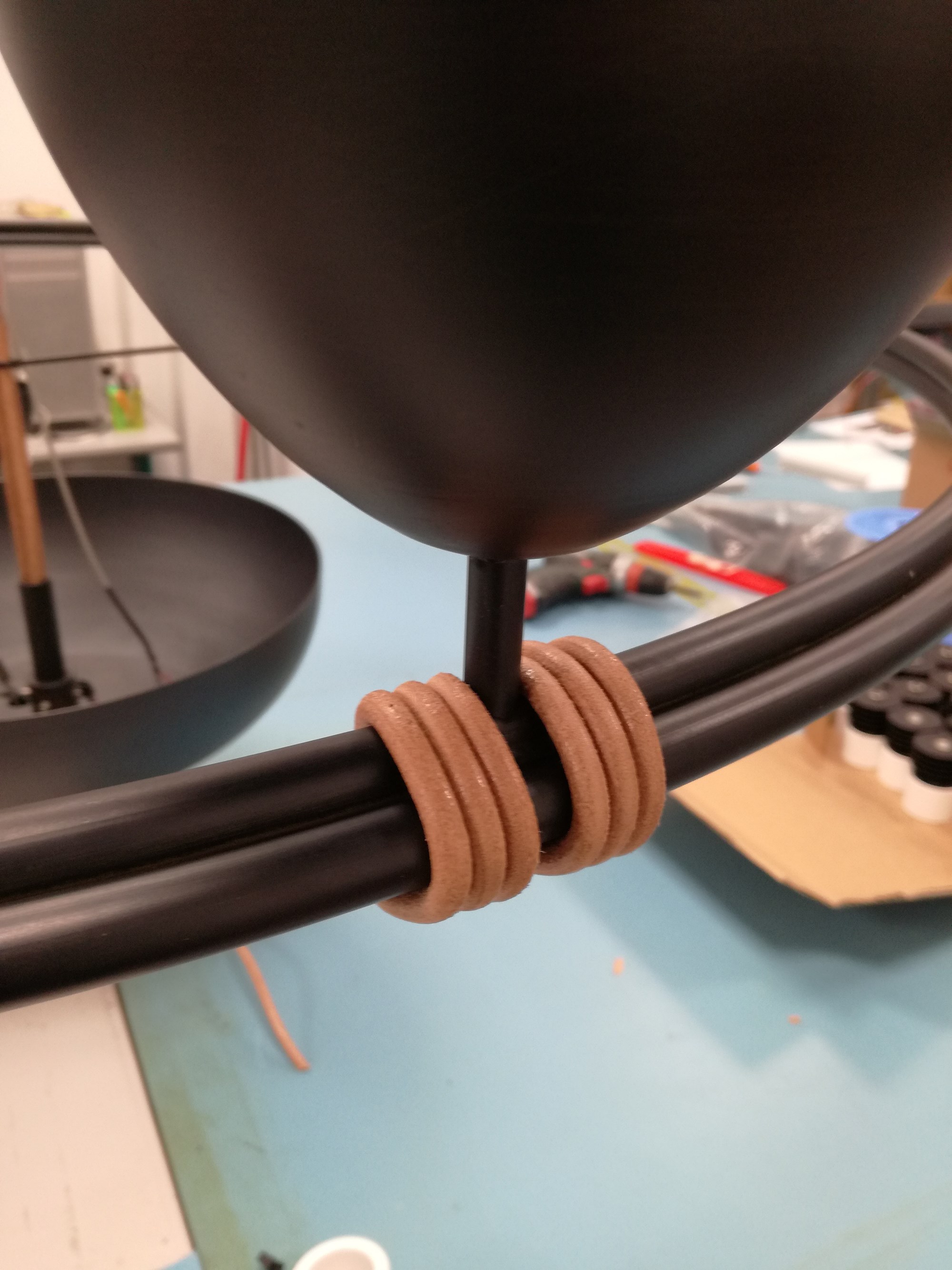 Luminária suspensa com luz indireta em ferro polido e couro.